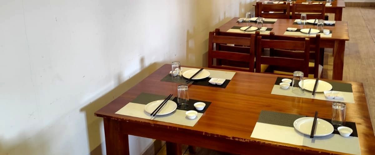 Side view of the Ajito restaurant featuring wooden dining tables with cutlery arranged over it at Ilara Hotels & Spa, Tada.