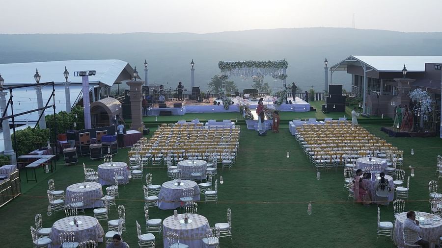An image of a large wedding lawn featuring several chairs facing the stage and behind it there are sets of table and chairs meant to organise wedding at The Grand Legacy Resort & Spa