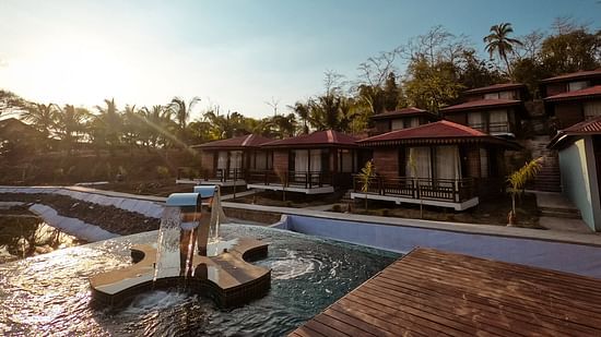 view of the outdoor swimming pool at symphony samudra beachside jungle resort and spa