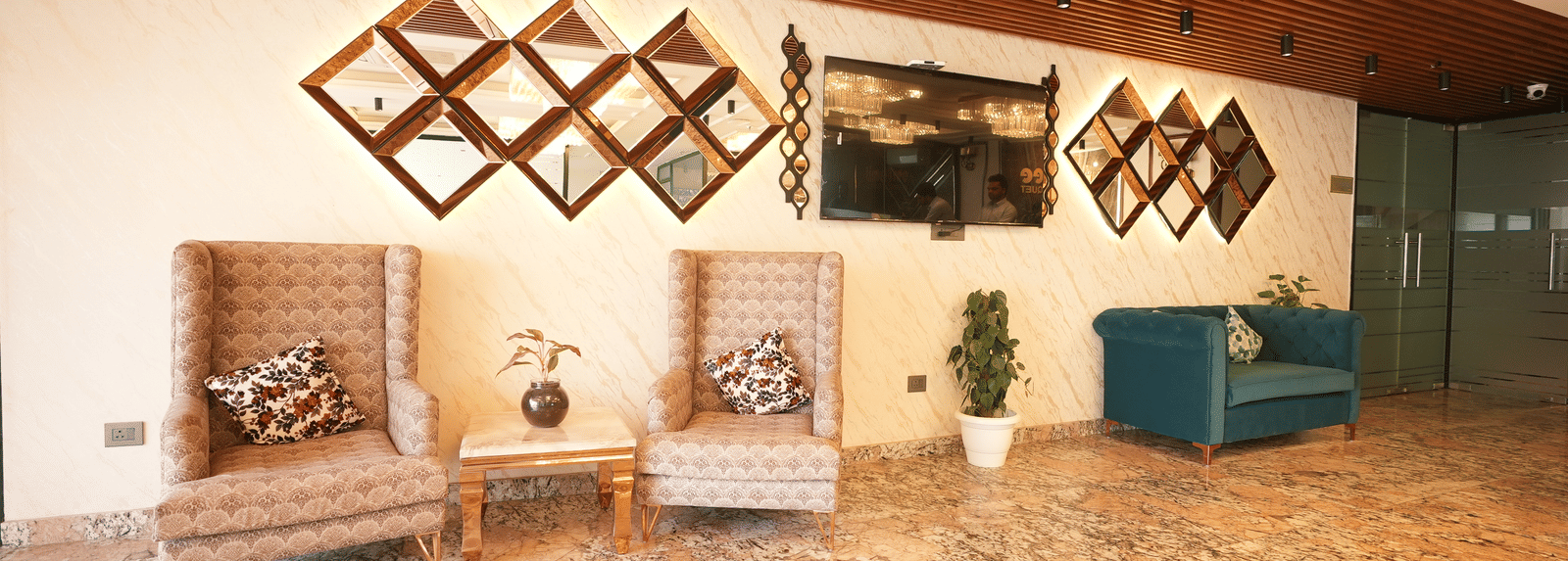 Stylish lounge with wall art and seating at Lime Tree Hotel Near India Expo Mart, Greater Noida.