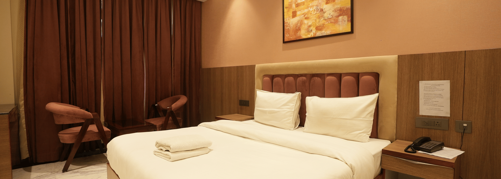 Warm-toned room with king size bed and curtains at Lime Tree Hotel Near India Expo Mart, Greater Noida.
