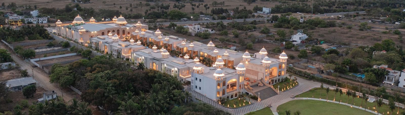 An aerial shot of the beautifully lit Kaldan Samudhra Palace in Mahabalipuram surrounded by lush greenery on all sides
