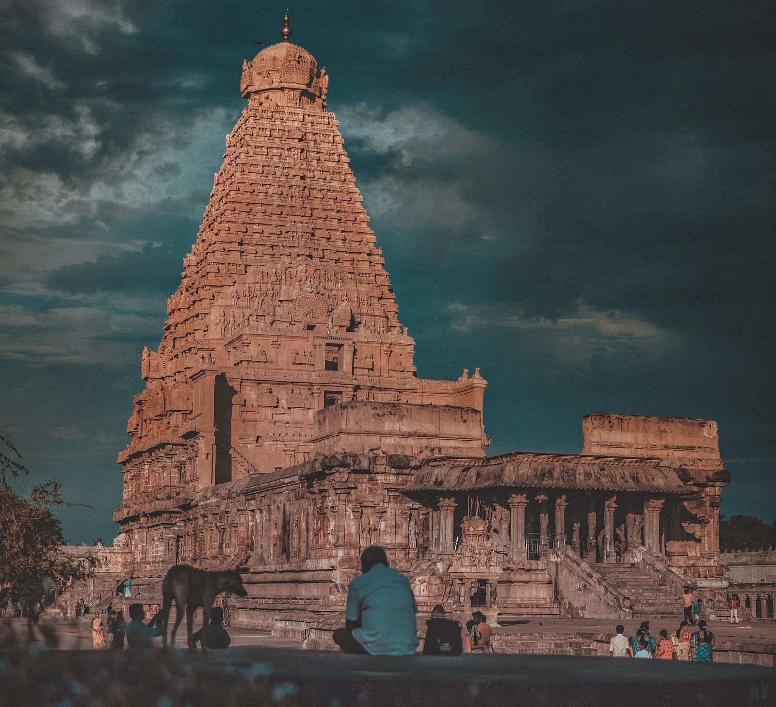 A hindu temple with intricate architecture outside on the roof as seen from a distance