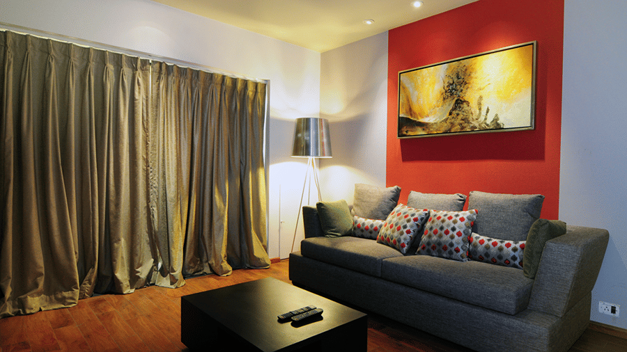 Corner view image of the living area with a grey coloured couch and a coffee table in the Premier Suite - Senses Hotel