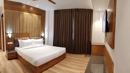 A large bed in front of the TV in Deluxe Non-view Room at DLS Ark Holiday Inn, Banikhet.