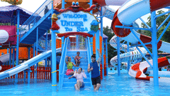 Family enjoying their time at a water park with multiple water slides, posing for a picture - Family Playstation, Black Thunder