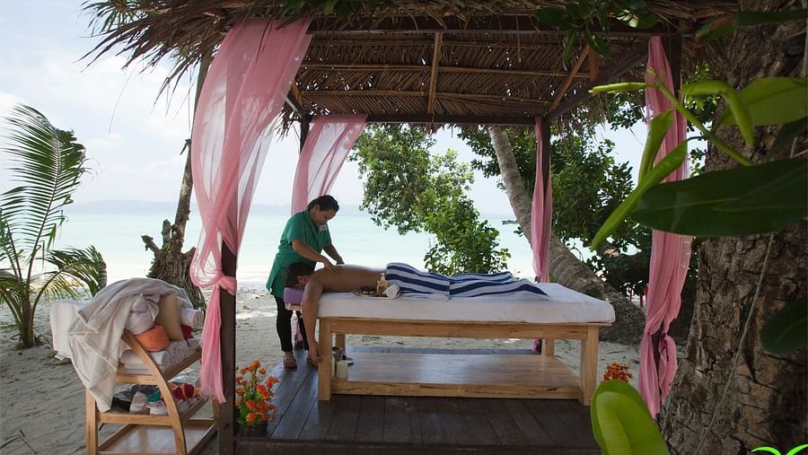 A person receiving massage next to the beach