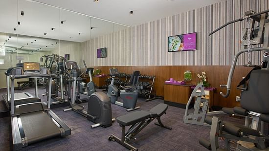 A gym room with a variety of fitness equipment, including treadmills and weight machines, offering a clean and organised workout space.