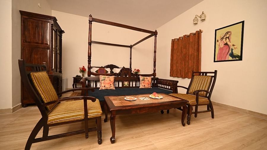 two seats and a teopoy are placed in front of the bed