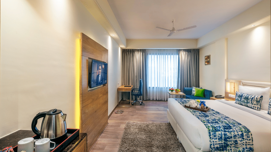 Relaxing big room with soft lighting, smart TV, small tea & coffee setup in the corner