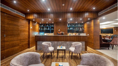 Another view of the bar area with a round central table and armchairs, creating a warm, intimate atmosphere.