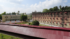 An overview of cellular jail in port blair with trees and blue sky in the background. It is the location of Light and Sound Show Port Blair.