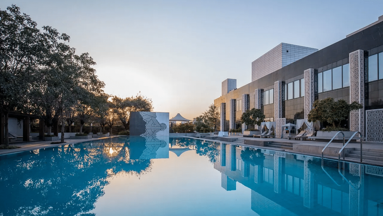 Swimming pool with surrounding buildings and trees at Karma Chalets.
