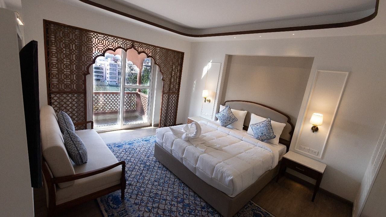 Top view shot of the Jalrupa Room featuring a double bed and a small balcony with huge french windows at Bhagirathi by RDB Atishay.