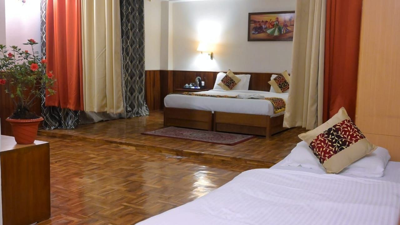 An image of the family room featuring two beds, bed side tables, indoor plants, and decorative lighting - Ecotel Chiminda, Pelling