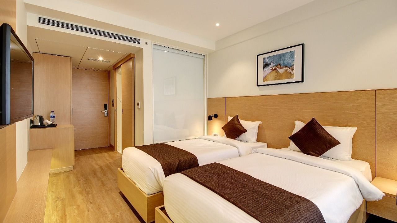 Premium Room with twin beds and a television at Hotel Mumbai House, Ghansoli
