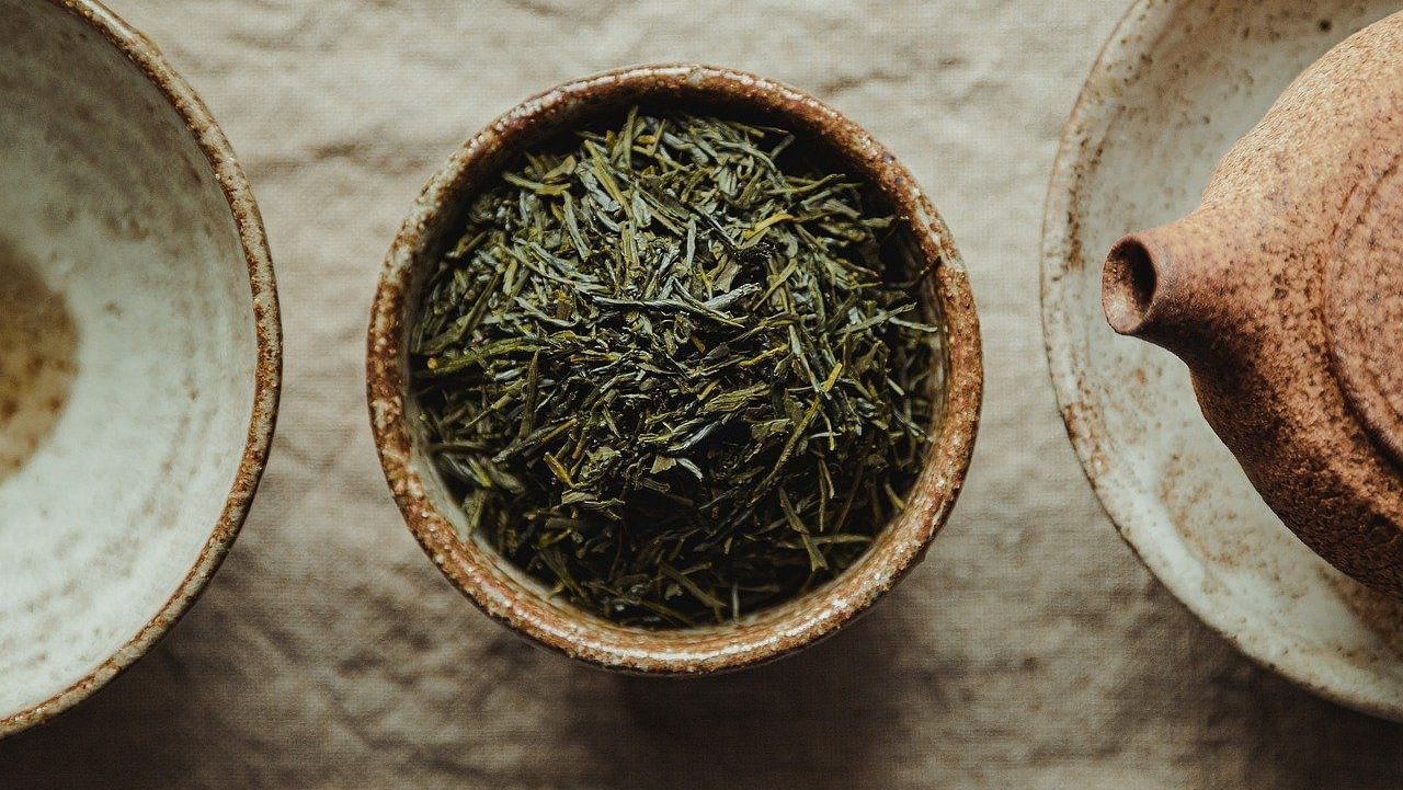 ??An image featuring a pot filled with green tea.