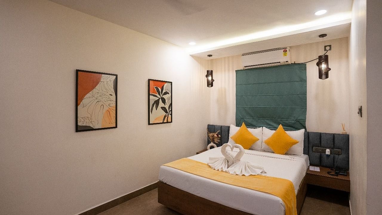 A well-lit room featuring a double bed with pillows and minimalist artwork on the walls at Kyzen Smart Stays.