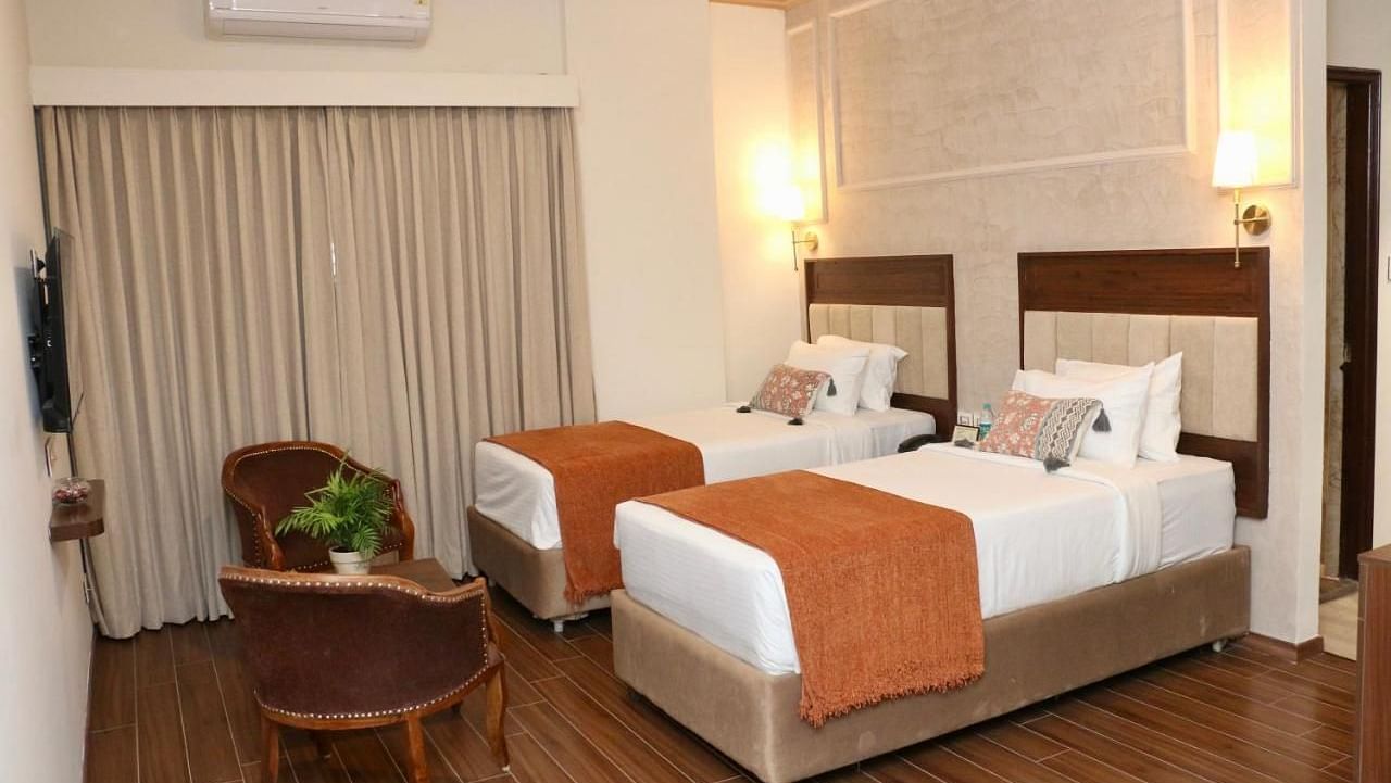 Luxury King Room at Nalapad's Hotel Bangalore International with two twin beds and chairs.