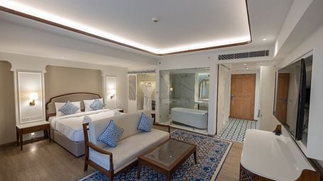 Full view shot of the Purna Room at Bhagirathi by RDB Atishay featuring a double bed and a couch in front of it at Bhagirathi by RDB Atishay. 