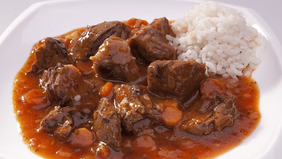 An overview a plate with Goan Pork Vindaloo with a side of rice.