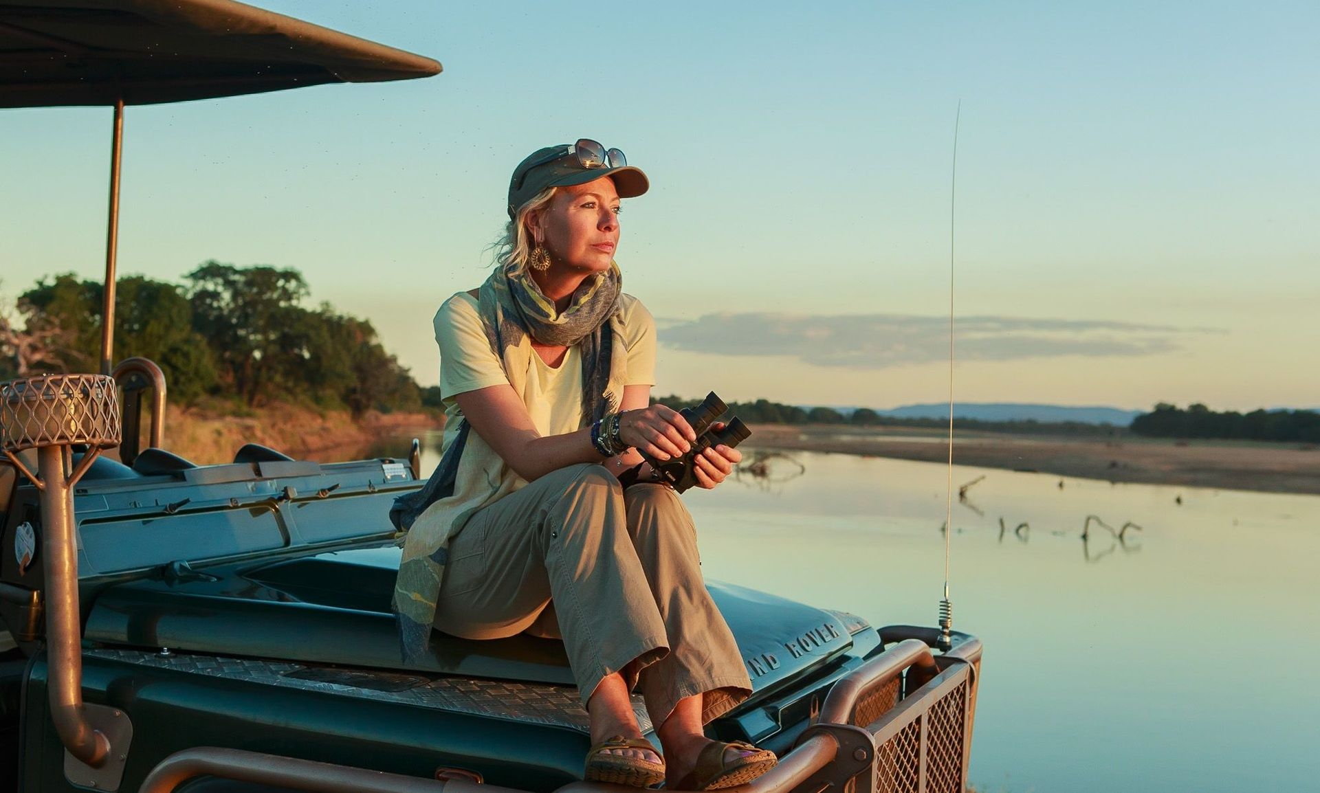 Margot Raggett on safari vehicle with binoculars.