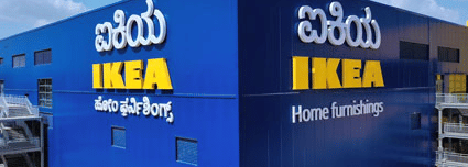 A bright facade of IKEA Bengaluru, featuring a bright blue exterior colour with the brand name written in English and Kannada language.
