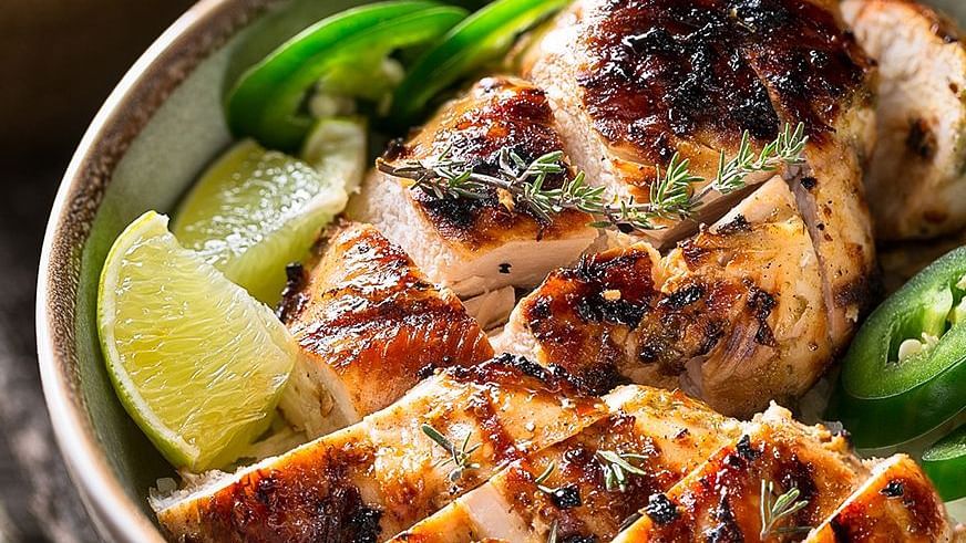 A close up shot of grilled chicken surrounded by lime slices - S Hotel Montego Bay, Jamaica