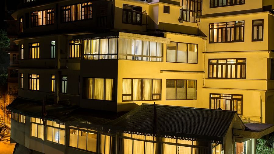 The exterior of New Orchid Lords Inn Gangtok is shown at night with illuminated windows across multiple stories.