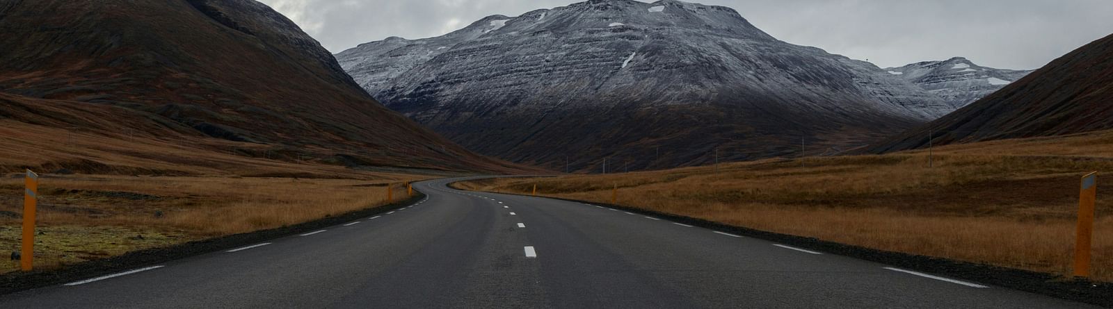 An overview of a highway with single lanes on either side and a mountain in the background.