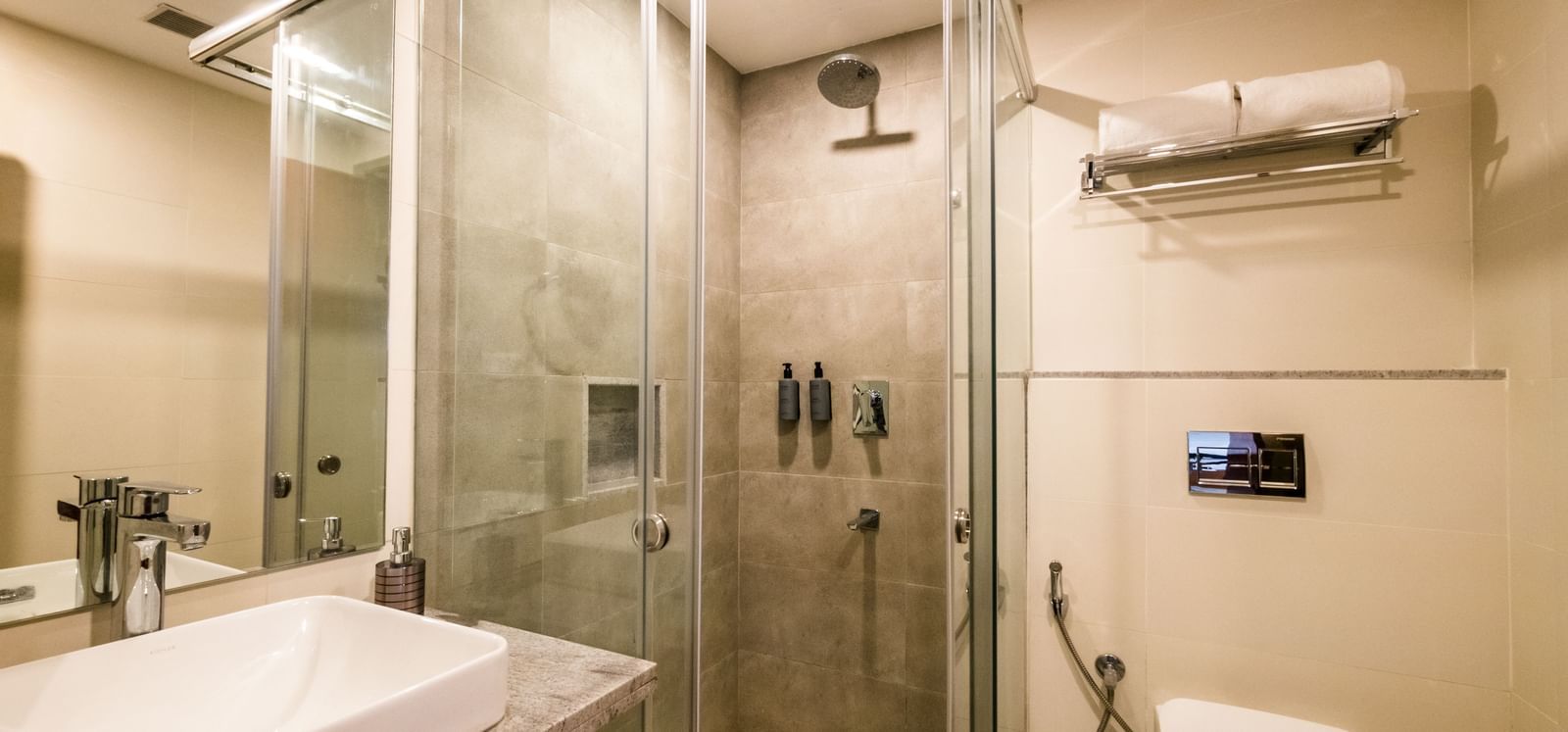 A modern bathroom with a glass enclosed shower and a sleek sink, featuring a minimalist design at Shilton Dee Cee.