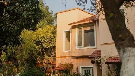 Exterior view of a cottage partially shaded by trees at Karma Chalets.
