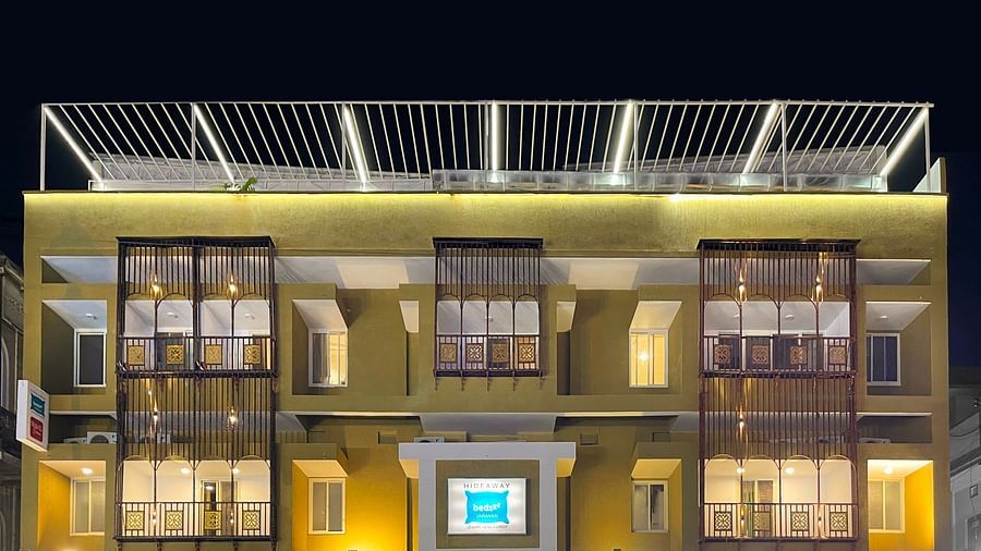 A close image of the front view of Bedzzz Varanasi, captured in the evening, well lit and featuring the logo of the property and the roof top area.