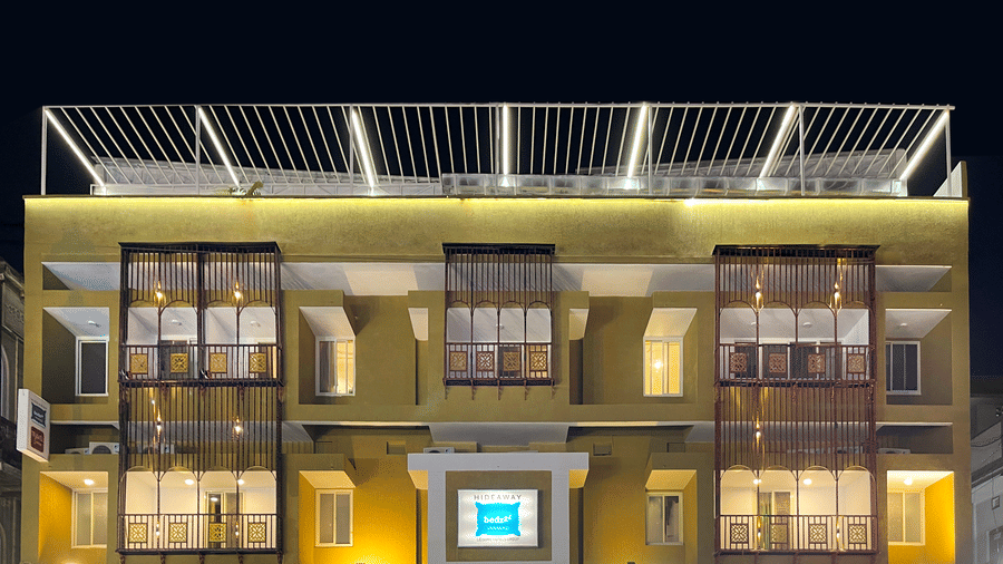 A close image of the front view of Bedzzz Varanasi, captured in the evening, well lit and featuring the logo of the property and the roof top area.