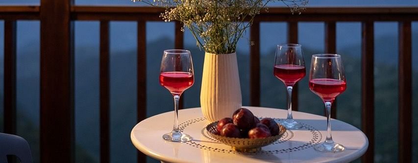 An image of glasses of wine with fruits placed on a table | Avalon Cottages, Kanatal