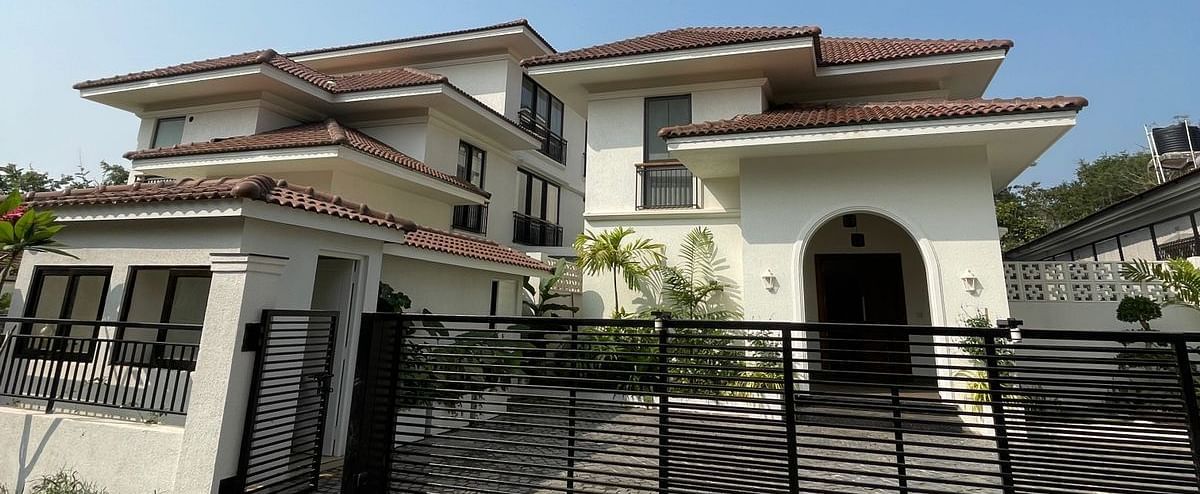 A luxurious villa with a gated entrance, showcasing a grand facade against a clear blue sky - BluSalzz Villas - Alocassia, Anjuna.