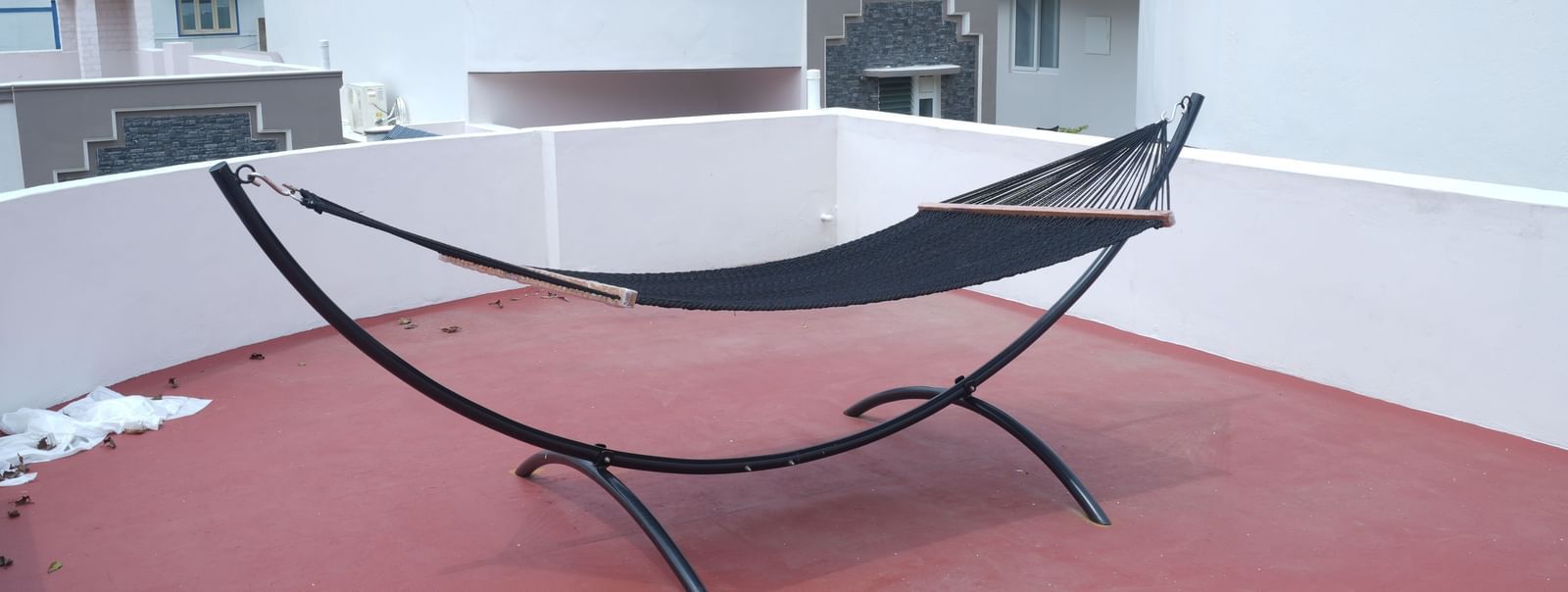 A hammock kept on the terrace area with red flooring at the Terrace Cottage at WOW Naturefull Resorts.