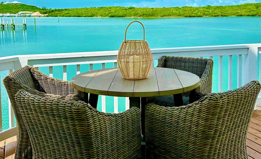 A deck with multiple armchairs and a round table with an ocean view at Elbow Room Villa 7 in  Abaco inn 