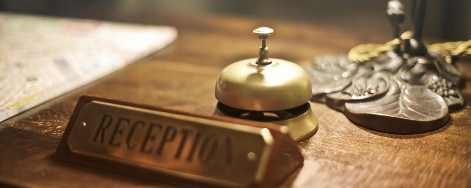 A reception bell and keys placed neatly on a desk.