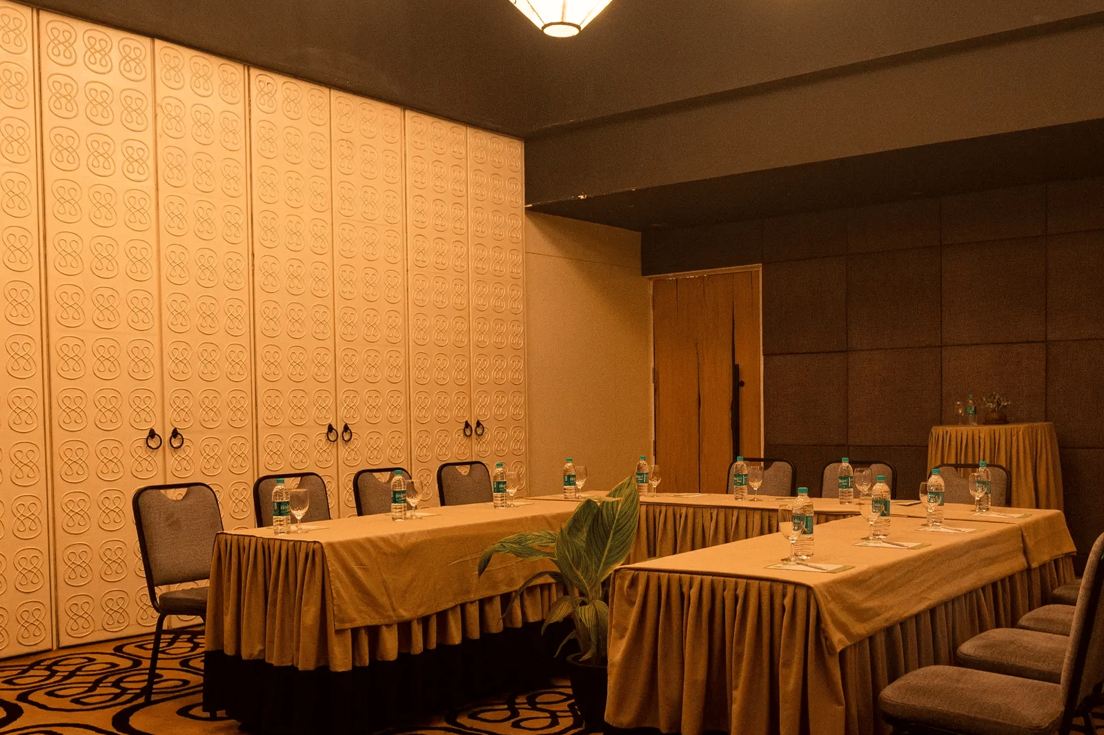 Boardroom table setup with bottled water and chairs in Dholavira banquet hall at 3102bce - A Vedic Resort by Lindsay.