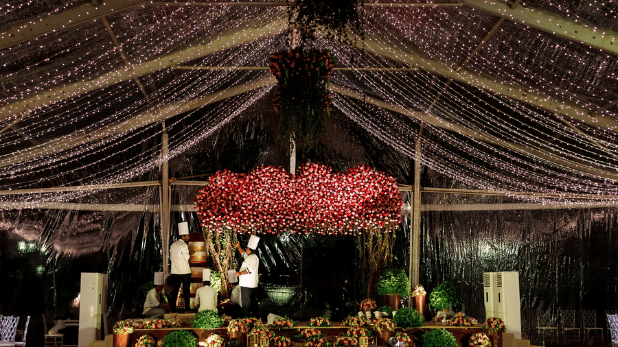 Indoor event space with beautiful ceiling decorations of hanging floral arrangements, draped lights, and elegant floral centrepieces at Black Thunder, Coimbatore