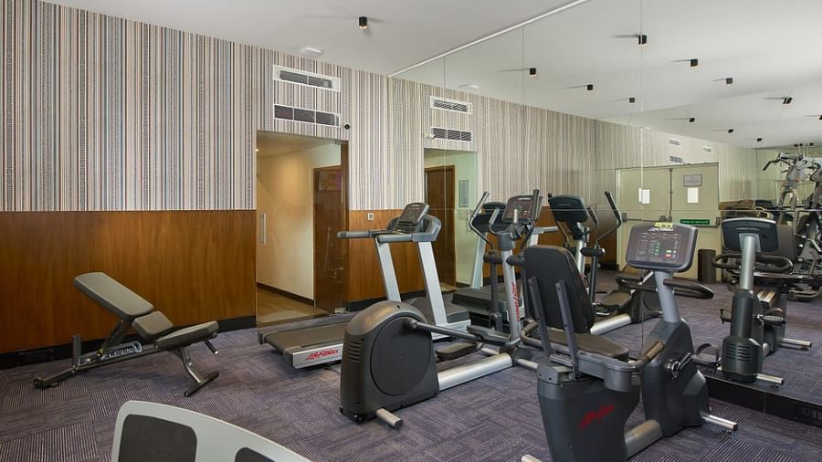 A corner of the gym with multiple machines available for use, offering a comfortable space for strength and cardio workouts.