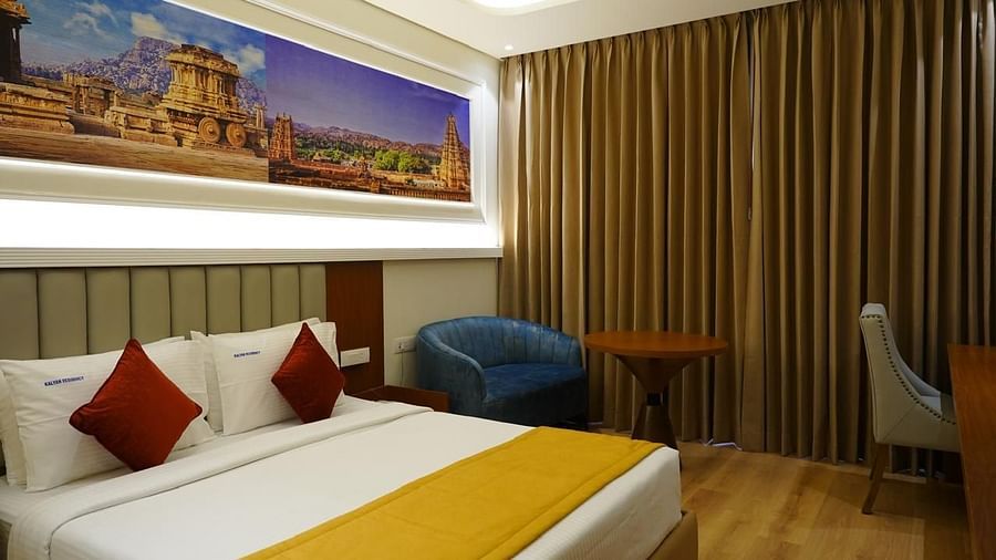 Room with ample lighting, decor accents, and functional workspace at Kalyan Residency Hotel, Tirupati.