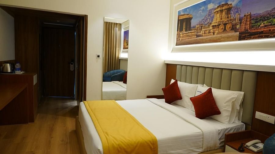 King room with wall art and cosy lighting at Kalyan Residency Hotel, Tirupati – ideal for a restful stay.