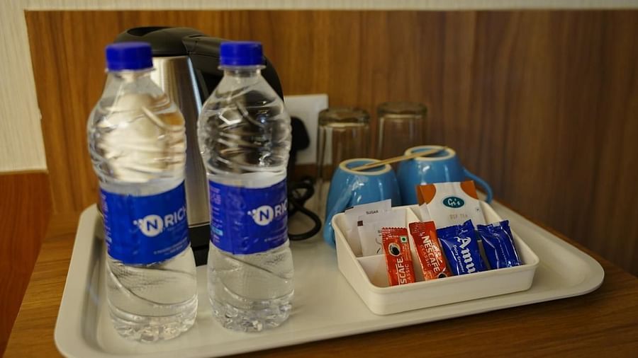 In-room refreshment tray with water bottles, glasses, and tea/coffee kit at Kalyan Residency Hotel, Tirupati.