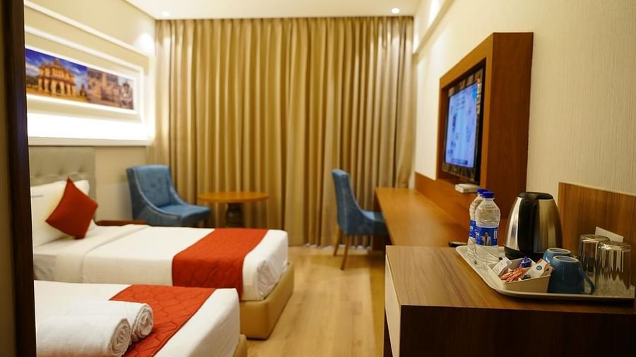 Twin room with window seating and amenities at Kalyan Residency Hotel, Tirupati – ideal for comfort and convenience.