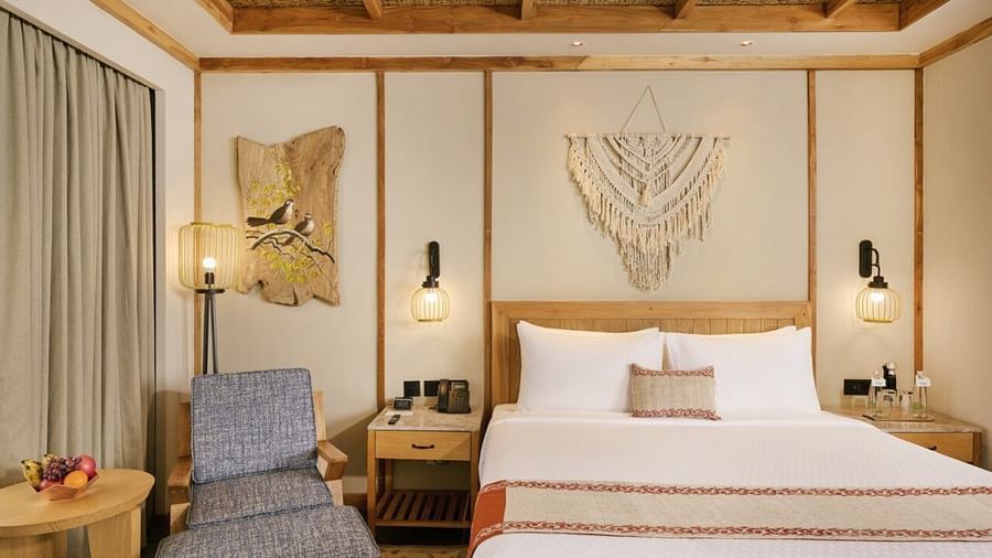 Stylish room with double bed, seating space, and warm pendant lights - Royal Tulip, Chitwan