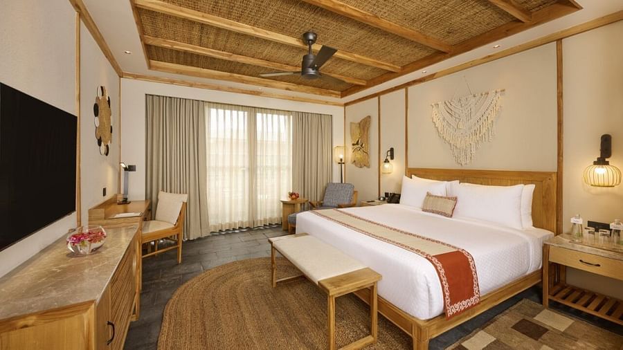 Modern hotel room with rustic wood textures, a double bed, and cosy, relaxing ambience - Royal Tulip, Chitwan