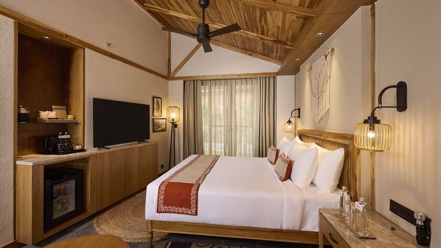 Room with double bed, fan, a minibar, flat-screen television, a desk, and wooden accents - Royal Tulip, Chitwan