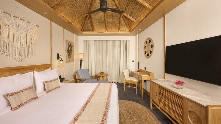 A spacious room with double bed, ceiling fan, television, and balcony access - Royal Tulip, Chitwan
